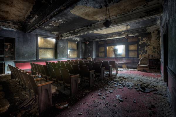The decaying interior of an abandoned theater with rows of chairs, from 'Photographing Abandoned Histories'