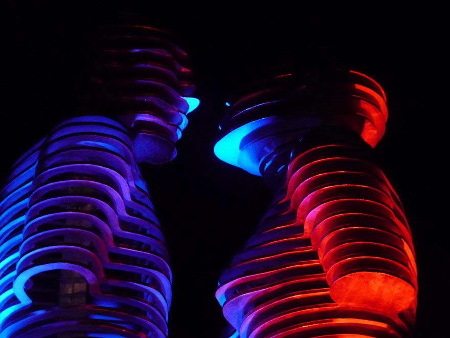 Glowing blue and red coiled sculptural forms facing each other, titled 'Statue of Love'