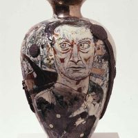 Ceramic vase with a bronze glaze sculpted into the shape of a weathered human face and torso
