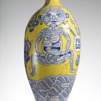 Yellow ceramic vase hand-painted with a blue-and-white seated robotic figure and wave patterns