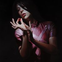 Painting of a woman in a pink top with hands raised near her face, under dramatic dark lighting
