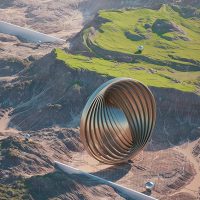 Digital artwork of a cylindrical metal tunnel floating over a green mountain landscape