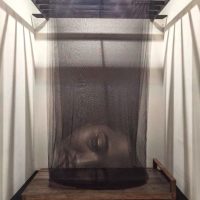 Photograph of a shrouded figure displayed inside a glass museum case