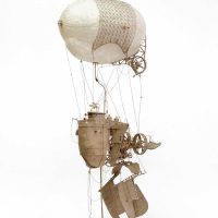 Sepia-toned photograph of a whimsical mechanical sculpture resembling a walking hot air balloon contraption
