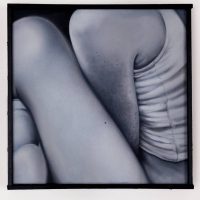 Close-up black-and-white photograph of clasped, crossed arms