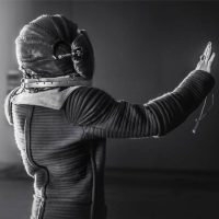 Black-and-white photograph of a standing sculptural astronaut figure reaching a hand outward