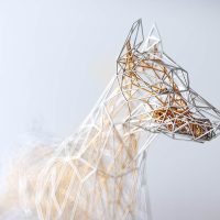Wireframe sculpture of a fluffy-coated dog in golden wire mesh