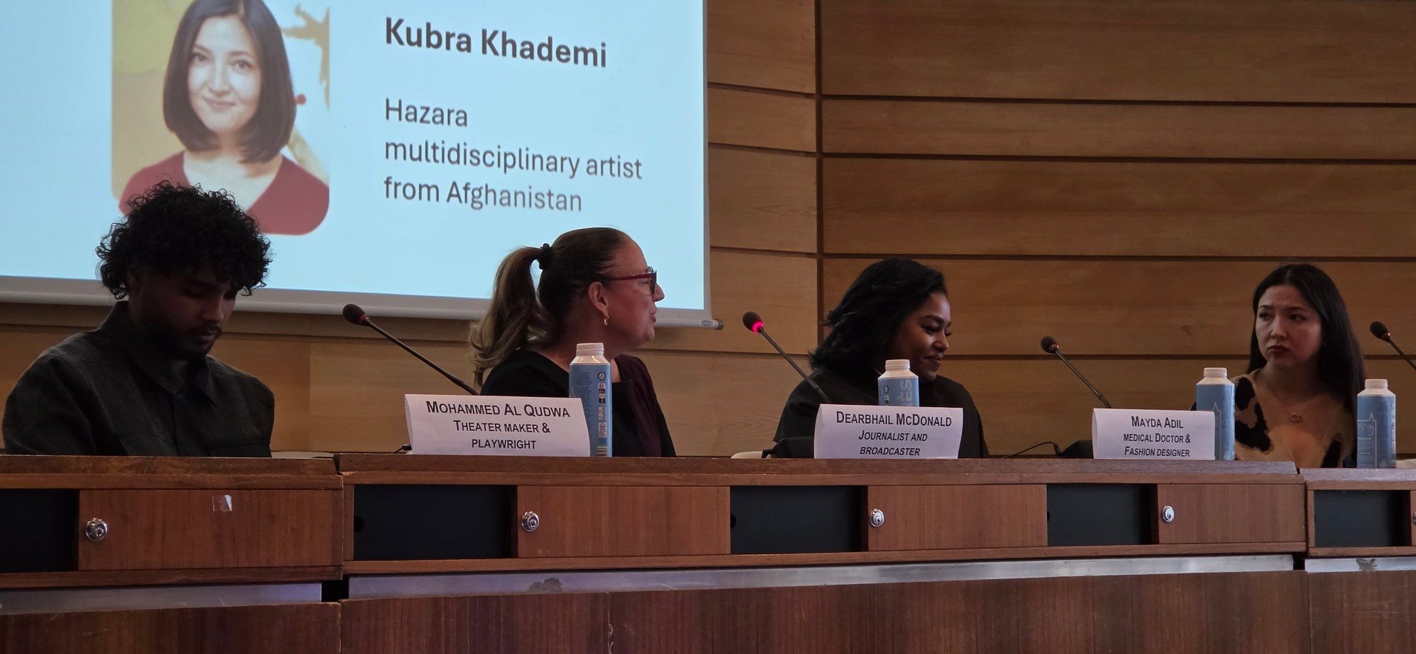 Mohammed Al Qudwa, Dearbhail McDonald, Mayada Adil and Kubra Khademi seated at the panel table under the slide introducing Kubra Khademi