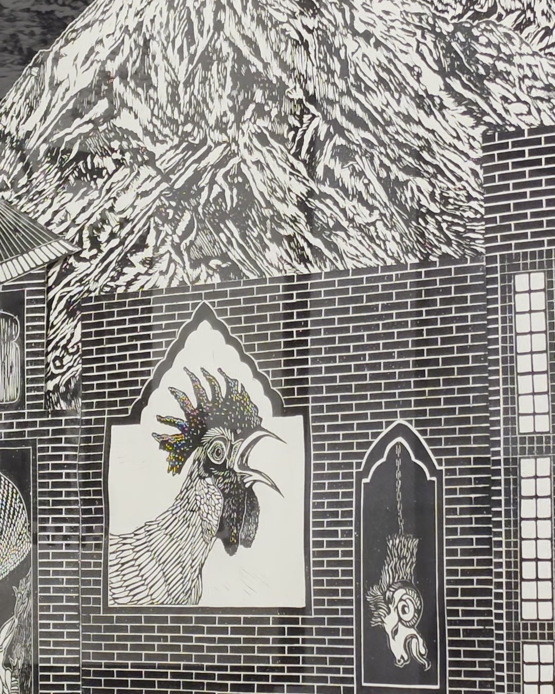 Détail d’un collage de linogravures en noir et blanc : montagnes enneigées au-dessus d’une façade de maison en briques avec un coq dans une fenêtre en arc et une base en damier